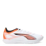 Championes de fútbol Puma Ultra 5 Play TT, diseñados para césped artificial y superficies duras. Presentan un diseño ligero en color blanco con detalles gráficos en naranja y negro, incluyendo el logo de la marca en el lateral. Cuentan con suela de goma de perfil bajo para mayor tracción y cierre con cordones.