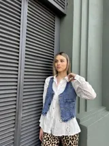 Chaleco de jean azul con bolsillos frontales y cierre de botones.