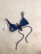 Top de bikini verde militar brillante, estilo triángulo, con argollas decorativas, bretel decorativo removible, forro y relleno removible. Los breteles son regulables y se ata en la espalda.