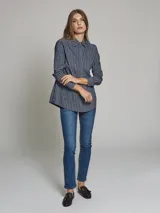 Camisa azul con rayas verticales blancas, de corte clásico, con cuello camisero y mangas largas.