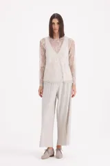 Pantalon tipo palazzo de corte amplio y tiro alto, confeccionado en tejido plisado con acabado brillante.