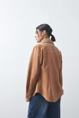Sobrecamisa de gamuza color marrón con bordados decorativos estilo western en la zona de los hombros y cierre frontal con botones metálicos.