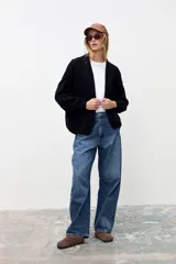 Cardigan de punto color negro, con diseño abierto sin botones, mangas largas con puños ajustados y corte holgado.