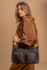 Bandolera de tafeta impermeable color beige, con dos bolsillos frontales con cierre y correa regulable. Diseño práctico y liviano ideal para uso diario.