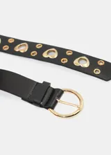 Cinto negro de cuero sintético con ojales redondos y corazones dorados, y hebilla redonda dorada con detalle de corazón.
