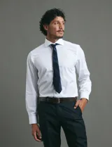 Camisa de vestir de manga larga, confeccionada en popelina fina de algodón, con cuello clásico y cierre frontal de botones.