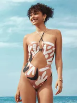 Traje de baño enterizo con estampado abstracto en tonos marrón, blanco y negro. Presenta escote halter con abertura en el centro y corte en la cintura.