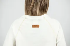 Remera blanca de corte clásico con mangas largas y cuello redondo.