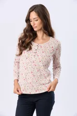 Remera de manga larga color beige con estampado floral en tonos rosados y verdes. Tiene cuello redondo y botones frontales.