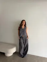 Conjunto de lino gris con diseño a rayas verticales, compuesto por un chaleco sin mangas con botones frontales y un pantalón largo de corte amplio.