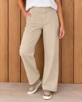 Pantalón de gabardina color beige, de corte recto y holgado, con pretina frontal, elástico en la parte posterior de la cintura y bolsillos laterales.