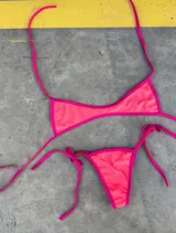 Conjunto de bikini con corpiño triangular y bombacha cavada con tiras finas.