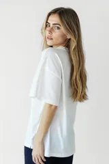 Remera blanca con estampado de flores y texto 'Smile'.