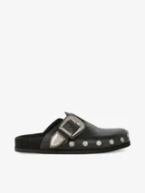 Zueco de cuero liso negro con plantilla anatómica forrada en gamuza, hebilla ajustable de estilo western en metal envejecido y tachas metálicas en el contorno.