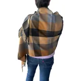 Bufanda rectangular de tejido afelpado con diseño de cuadros en tonos rosado, gris y beige. Presenta terminaciones con flecos en los extremos.