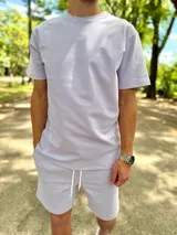 Conjunto deportivo compuesto por una remera de manga corta y un short lila con cordón de ajuste blanco.