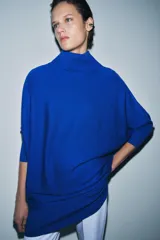 Jersey de lana en color azul vibrante, con cuello subido y diseño de manga murciélago con sisa ancha. Presenta puños ajustados y un corte holgado que se extiende hasta la cadera.
