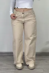Pantalón de jean color beige, estilo baggy o wide leg, de tiro medio, con cierre de botón y cremallera.
