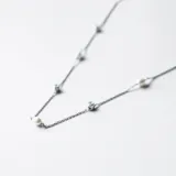 Gargantilla de plata 925 con diseño de cadena fina que alterna perlas de río naturales y pequeñas circonias engarzadas.