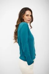 Buzo de tejido de punto fino en color turquesa, con cuello alto y mangas largas. Presenta un corte recto y terminaciones simples en puños y ruedo.