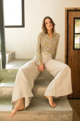 Pantalón de corte wide leg y tiro medio, confeccionado en lino. Presenta diseño de pierna ancha, cierre frontal con botón y bolsillos laterales.