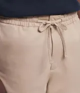 Bermuda recta de sarga color beige para hombre, con cintura elástica y cordón ajustable. Cuenta con bolsillos laterales y está confeccionada en una mezcla de algodón y elastano.