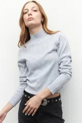 Polera de tejido de punto con cuello alto y diseño de rayas verticales sutiles. Presenta un ajuste al cuerpo y mangas largas.