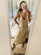 Vestido largo dorado con breteles finos y escote en V.