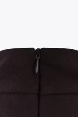 Top negro de cuello halter con cierre de botones en la parte trasera del cuello y espalda descubierta.