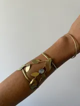 Brazalete dorado de bronce con diseño de hojas y piedra ágata celeste.