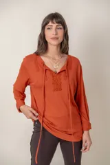 Remera color ladrillo de algodón con mangas largas y aplique de encaje en el escote.