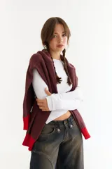 Top de manga larga color blanco, confeccionado en tejido de punto acanalado con diseño irregular y aberturas para los pulgares en los puños.