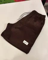 Short marrón de pana con cordón ajustable en la cintura y etiqueta con logo de la marca en el ruedo.