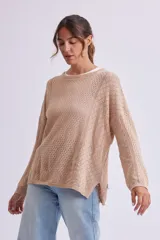 Buzo de punto fantasía color beige con diseño calado, escote redondo y mangas largas.