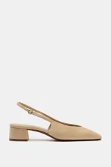 Zapato destalonado de serraje en color beige, con punta cuadrada, tira trasera ajustable con hebilla metálica dorada y tacón ancho bajo.