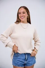 Sweater de tejido de punto acanalado en color crudo, con cuello redondo y mangas largas con puños ajustados.