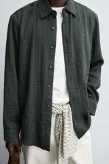 Camisa de corte relajado confeccionada en tejido fluido con mezcla de viscosa. Presenta cuello solapa, cierre frontal con botones y manga larga con puños abotonados.