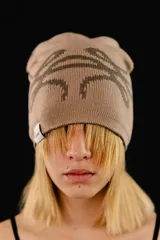 Beanie tejido reversible de algodón, con diseño gráfico abstracto en contraste. Presenta una etiqueta con logo en el borde inferior.