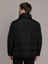 Campera acolchada Calvin Klein de color negro, con diseño matelasseado, cuello alto, cierre frontal con cremallera y bolsillos laterales con cierre. Incluye chaleco interior desmontable.