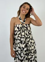 Top con estampado abstracto en blanco y negro, con cuello halter y espalda descubierta.