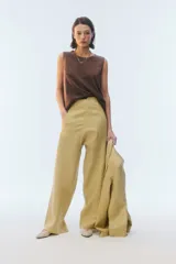 Pantalón de lino color tostado, de tiro alto y corte amplio con perneras rectas. Cuenta con pasacintos, bolsillos laterales y bolsillos traseros con solapa.