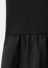 Vestido midi negro sin mangas, con cuello redondo alto y diseño combinado de cuerpo ajustado y falda amplia con vuelo.