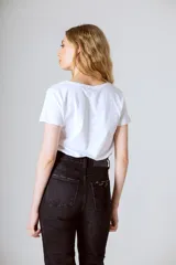 Remera blanca de algodón orgánico con cuello en V y mangas cortas.