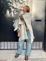 Camisa de corte holgado con estampado de cuadros escoceses en tonos beige y marrón. Presenta cuello clásico, cierre frontal con botones y mangas largas.