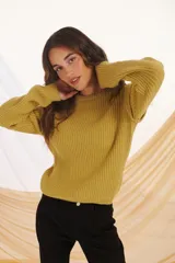 Sweater de punto color verde pistacho, de corte holgado y mangas largas.