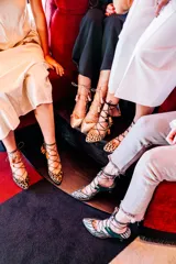 Zapatos de tacón con estampado animal print, detalles en ante negro, cordones finos y borlas decorativas.