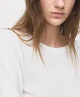 Remera de manga larga color blanco, con cuello redondo y diseño recto.