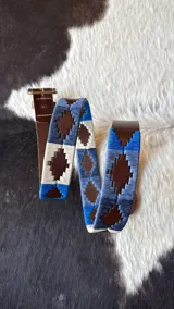 Cinturón de cuero marrón con diseño bordado a mano en tonos azules y beige, hebilla metálica rectangular y pasador de cuero.