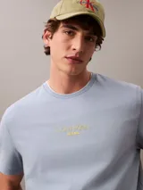 Remera de manga corta celeste con logo Calvin Klein Jeans bordado en amarillo en el centro del pecho.