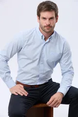 Camisa de manga larga con diseño de cuadros vichy en tonos celeste y blanco, cuello con botones y bolsillo ojal en el pecho.